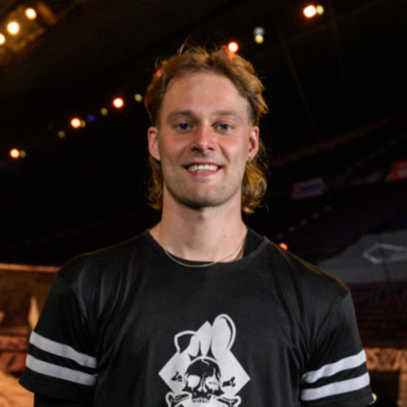 DMR Team rider, that is a human, with a name in-use of Arjan Ellens, standing up, with teeth on show, known as a smile.