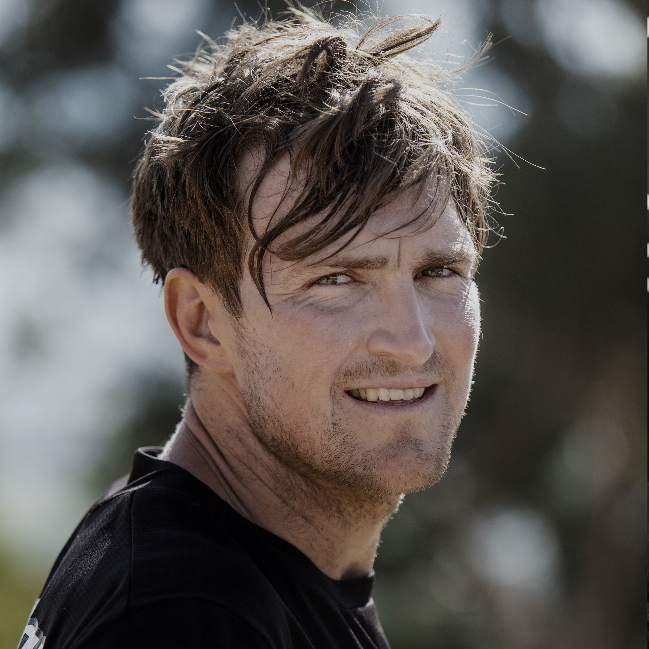 Man with wet hair outdoors, possibly after a swim or rain