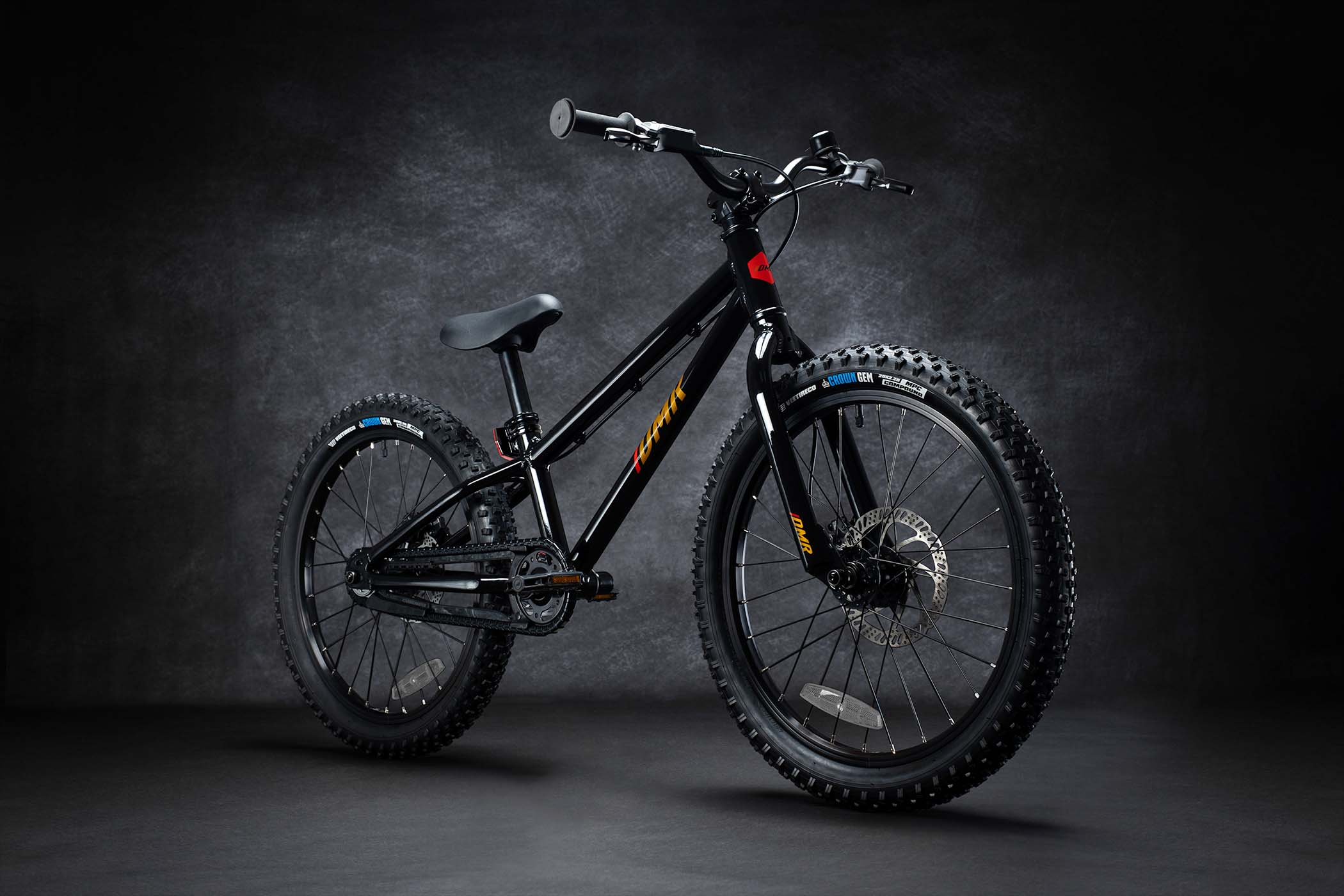 DMR Sidekick Ride Bike kids off-road mountain bicycle bike for children on a grey background. This DMR Sidekick Ride Bike kids off-road mountain bicycle bike for children is Black in colour.