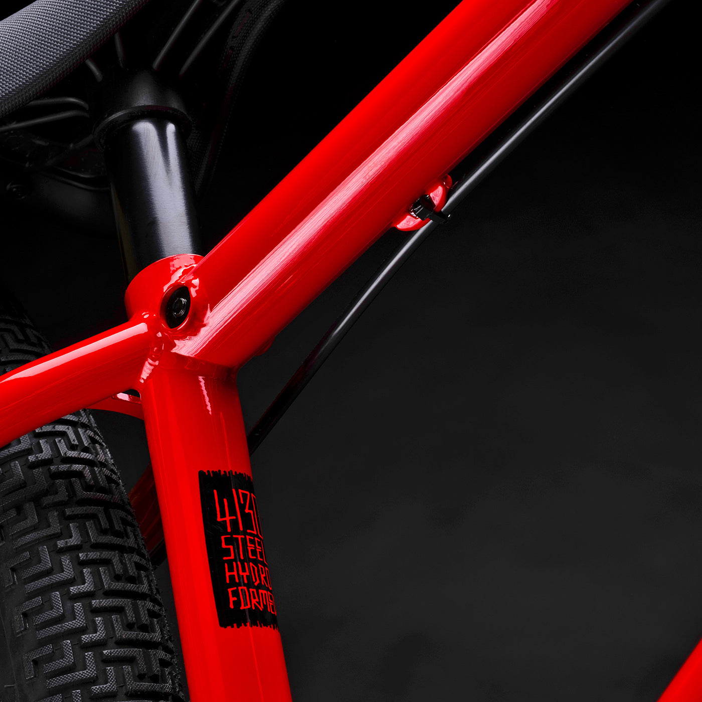 Close-up of a red bicycle frame with a black background