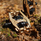 Close-up of the Light Bronze DMR VMAX clipless clip-in clip clipped SPD off-road mountain cycling bicycle bike pedalling pedal product, with an autumnal background composing of leaves other foliage.