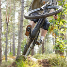 Grey DMR VMAX off-road mountain cycle cycling pedal pedalling product, under the foot of a rider, with a blurry green background.