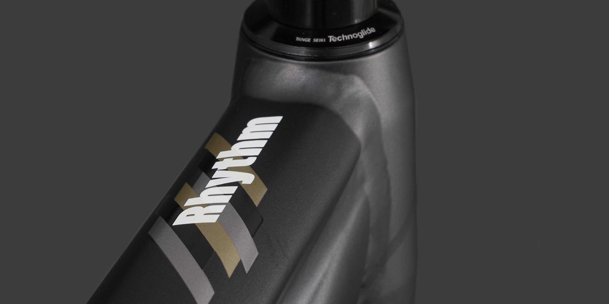 close-up of a dmr bikes rhythm expert dirt jumper bike frame in grey, on a dark grey background