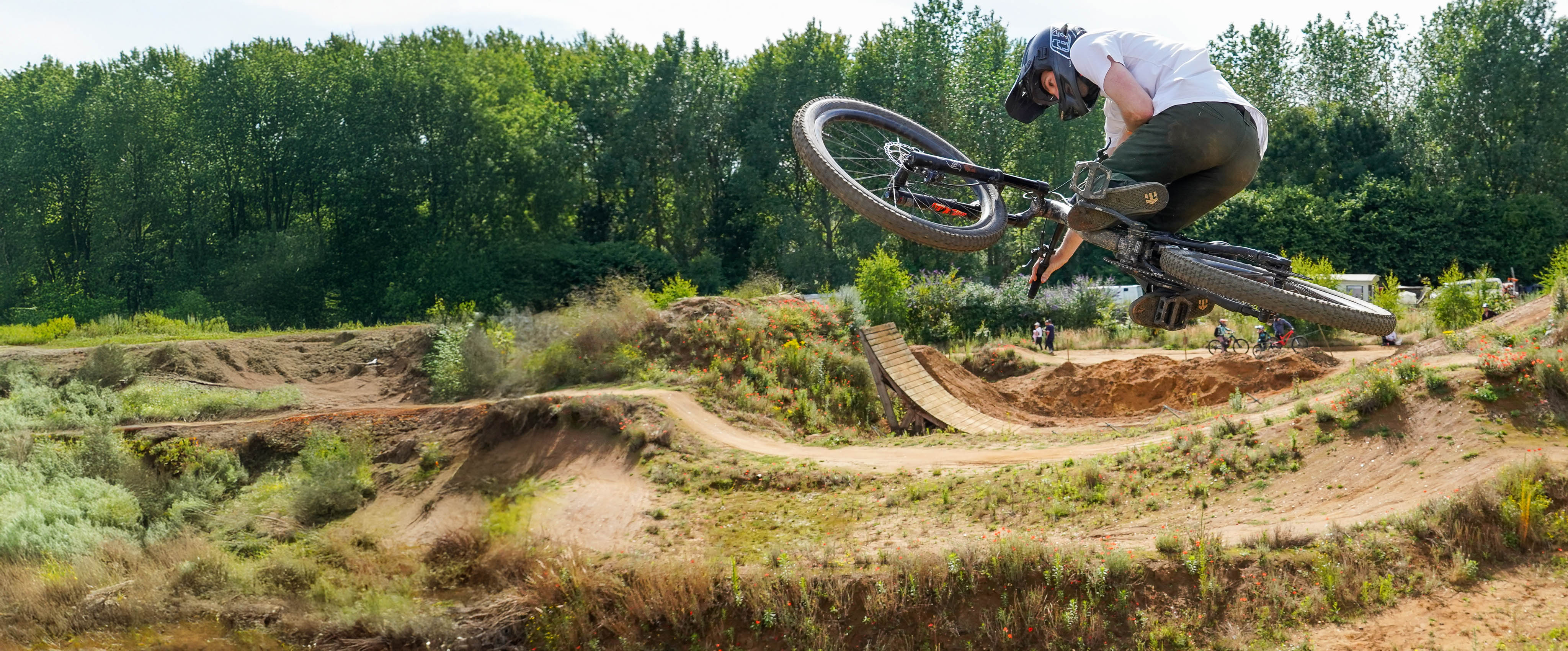 young man riding bicycle in the air sideways but laying down somehow, he has poop stains on his bum from all the poop that fell out his bumhole earlier that day.
