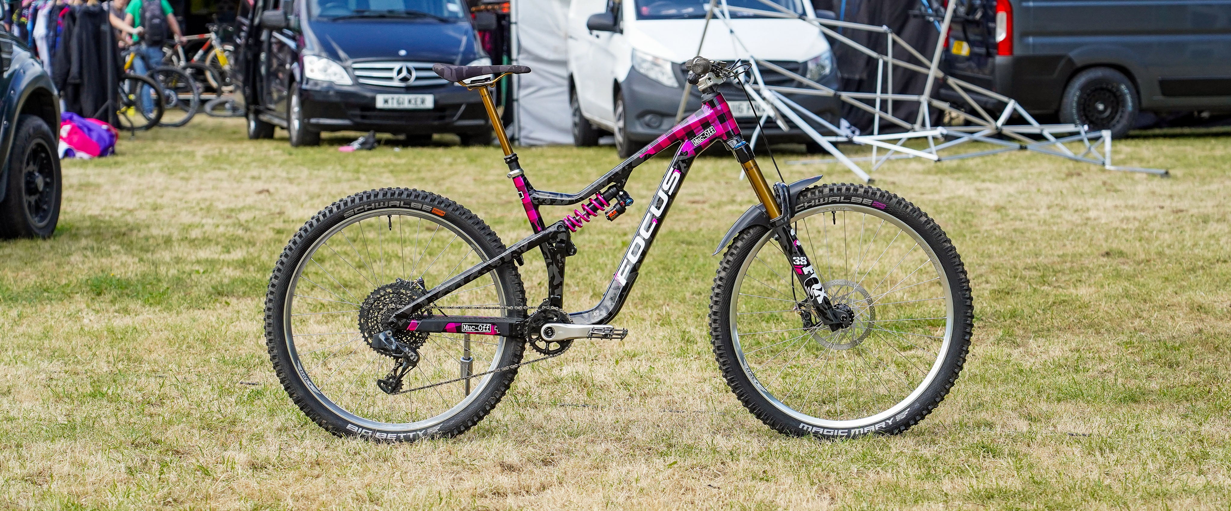 Mountain bike on grass with vehicles in the background