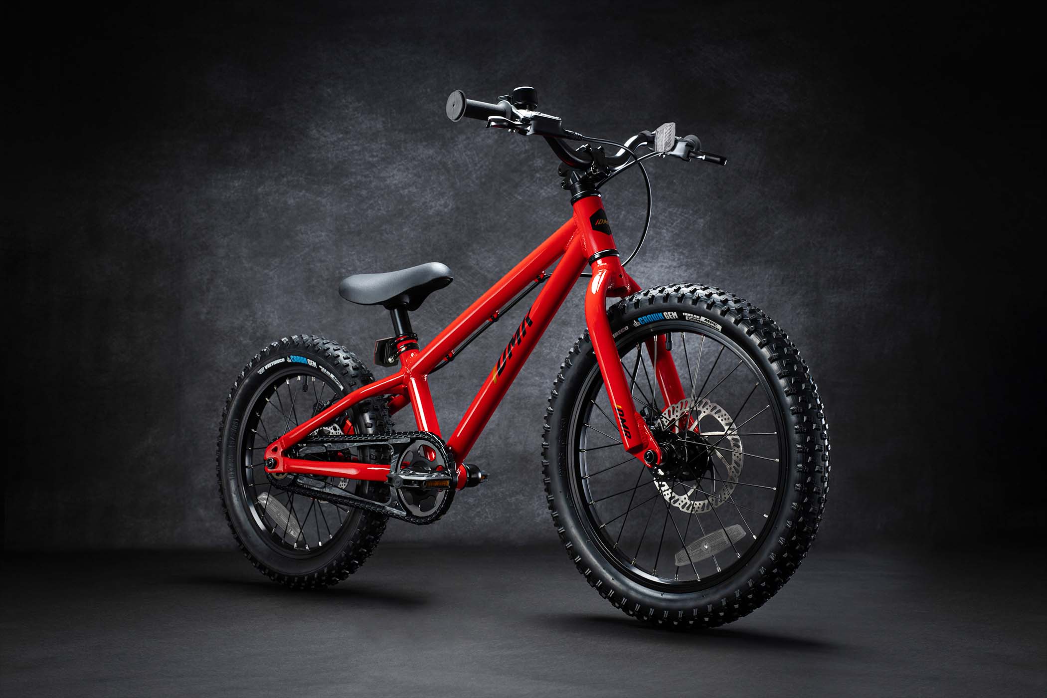 DMR Sidekick Pedal Bike kids off-road mountain bicycle bike for children on a grey background. This DMR Sidekick Pedal Bike kids off-road mountain bicycle bike for children is Red in colour.