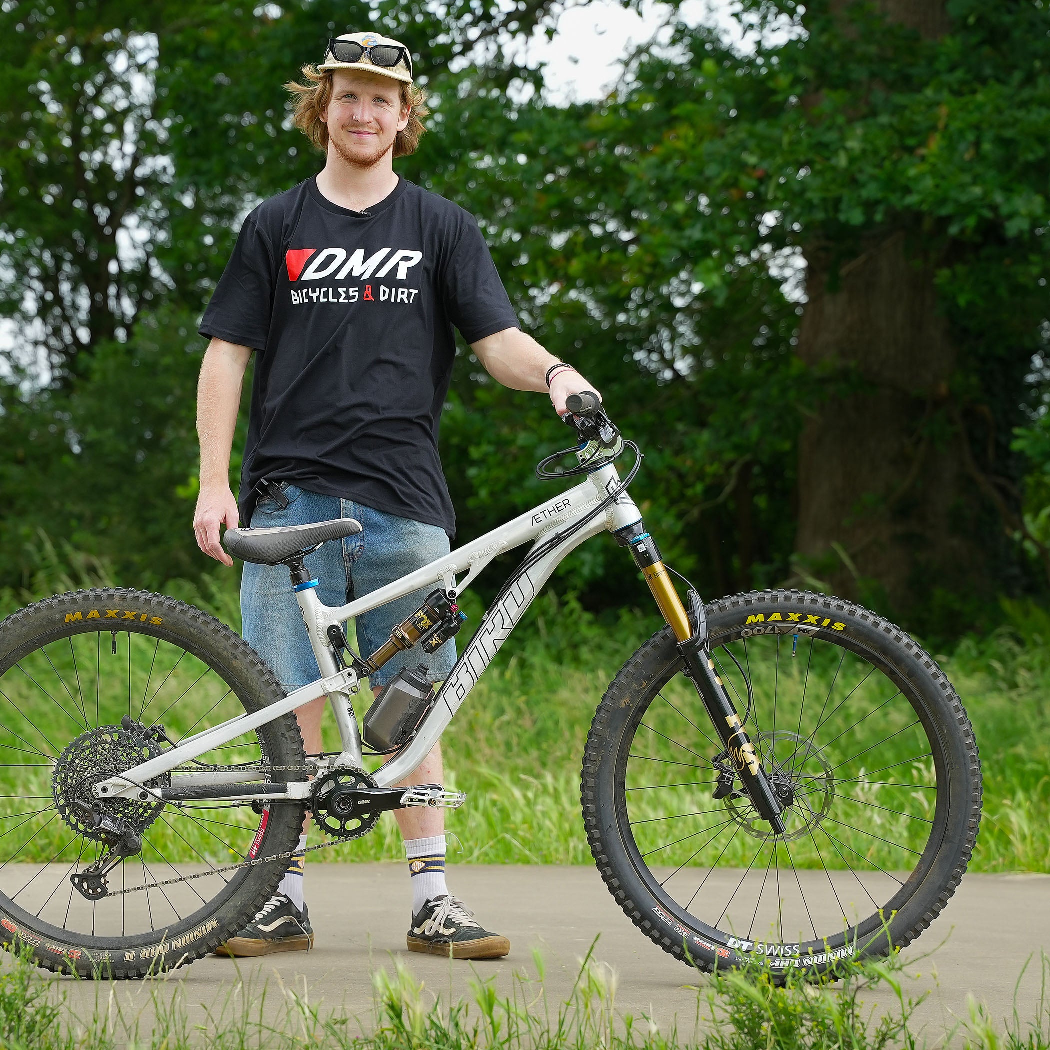 Team rider Andy Lehmann wearing a black t-shirt with DMR Bicycles & Dirt logo standing with his bike