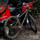 DMR team rider Olly Wilkins DMR Sect 26" bike leaning against a red mule vehicle in a woodland setting