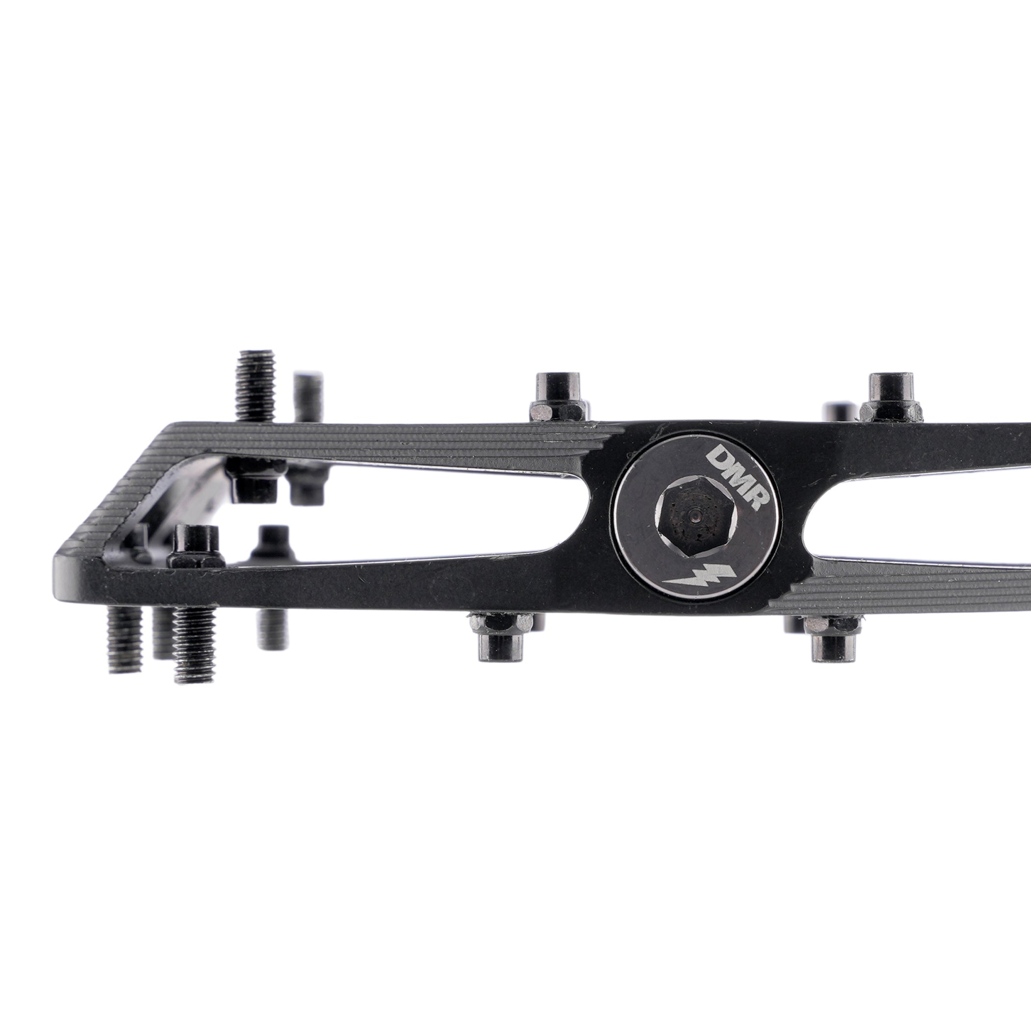 A black MTB pedal with mounting bolts and a circular silver logo plate reading 'DMR'.