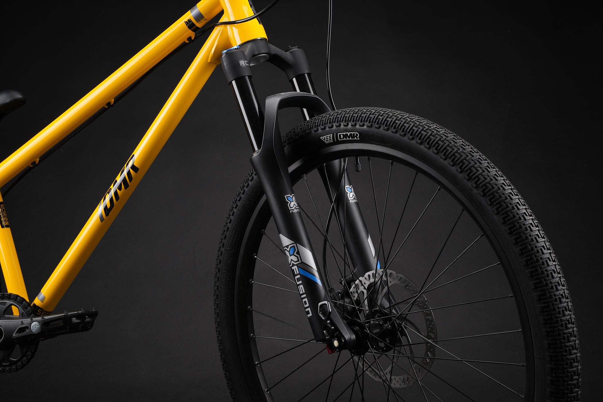 Yellow bicycle frame with black tire on a dark background