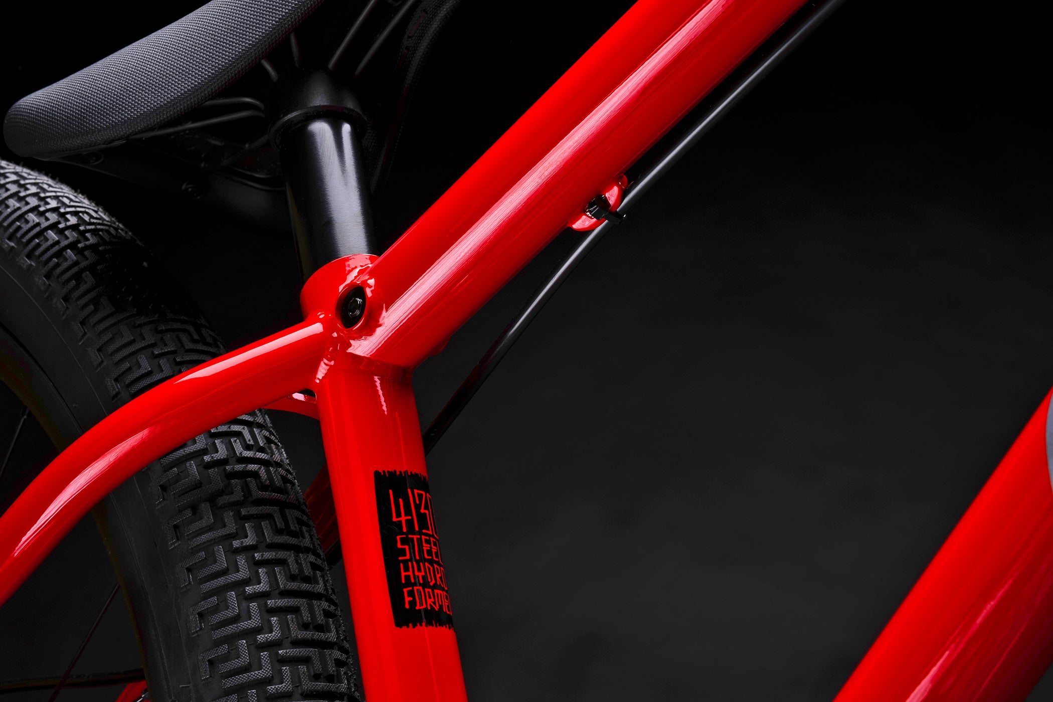 Close-up of a red bicycle frame with a black background