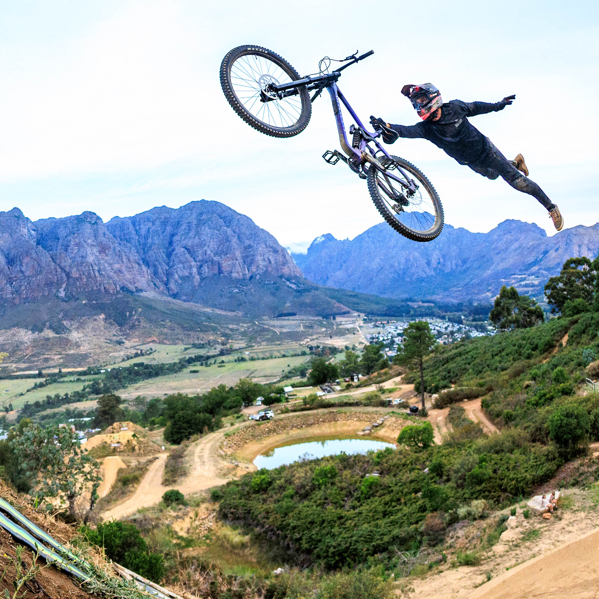 Person on a bicycle performing a jump with mountains in the background