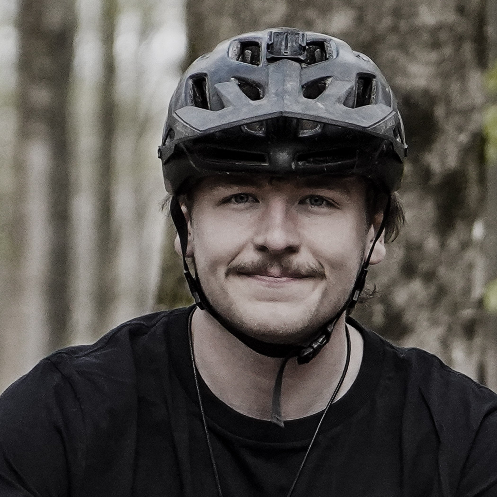 Person wearing a helmet with a forest background
