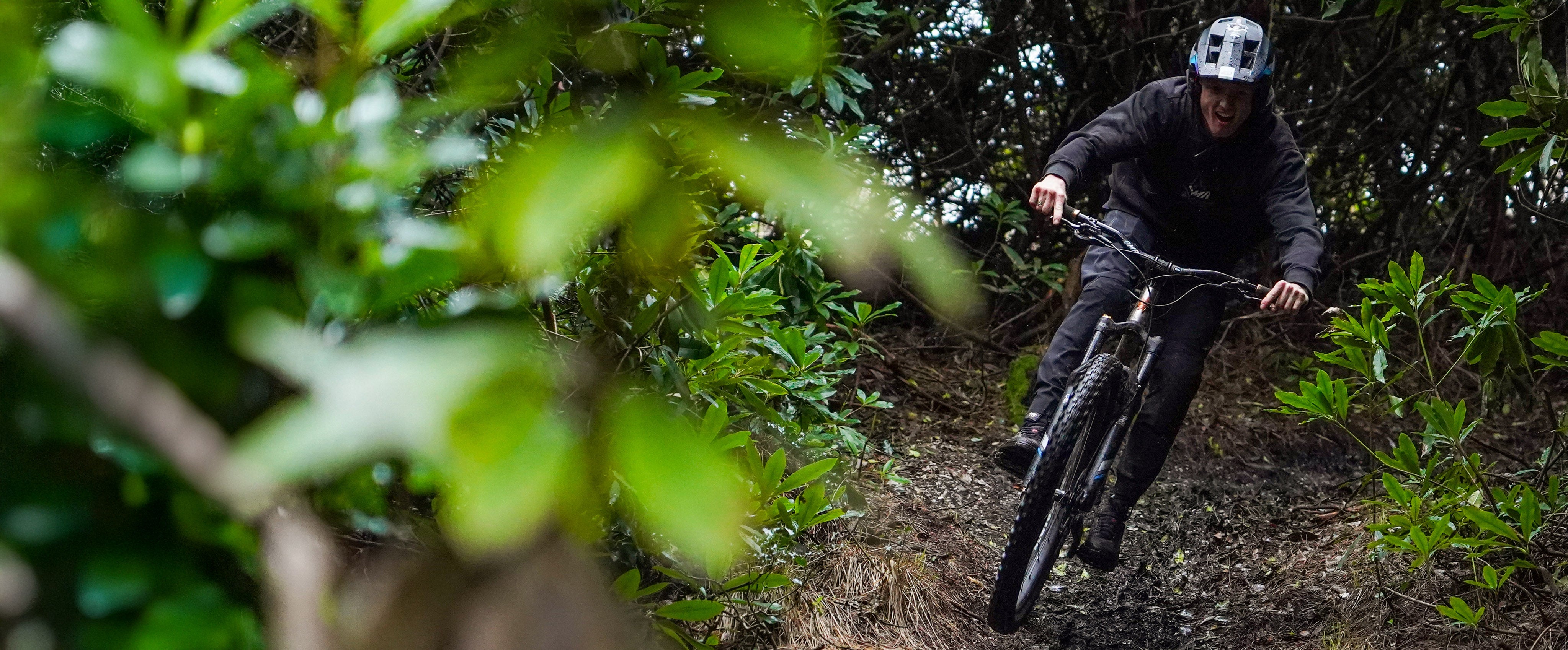 Person riding a mountain bike through a forest trail