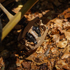 Close-up of the Light Bronze DMR VMAX clipless clip-in clip clipped SPD off-road mountain cycling bicycle bike pedalling pedal product, with an autumnal background composing of leaves other foliage.