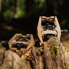 Close-up of the Light Bronze DMR VMAX clipless clip-in clip clipped SPD off-road mountain cycling bicycle bike pedalling pedal product, with an autumnal background composing of leaves other foliage.