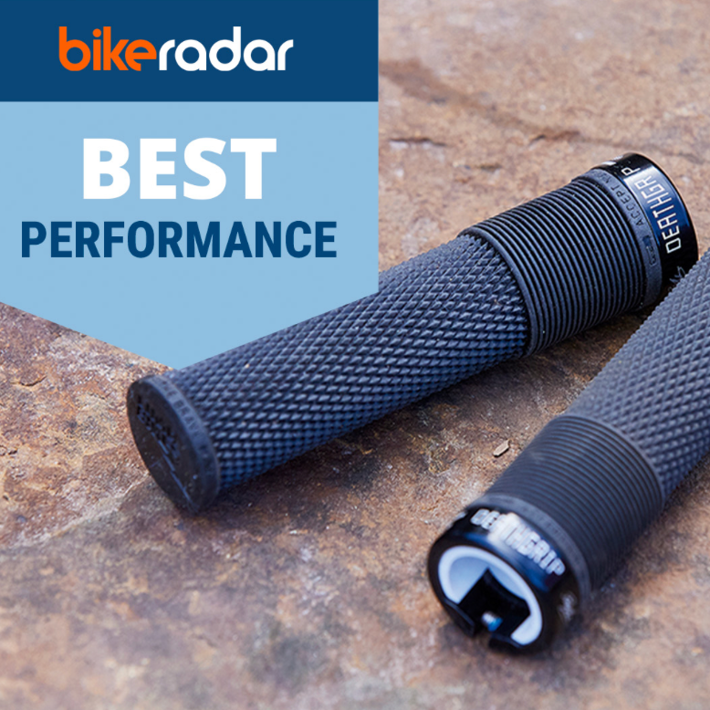 Two black textured bicycle handlebar grips lying on a stone surface, with a blue and white 'bikeradar BEST PERFORMANCE' graphic overlay in the top-left corner.