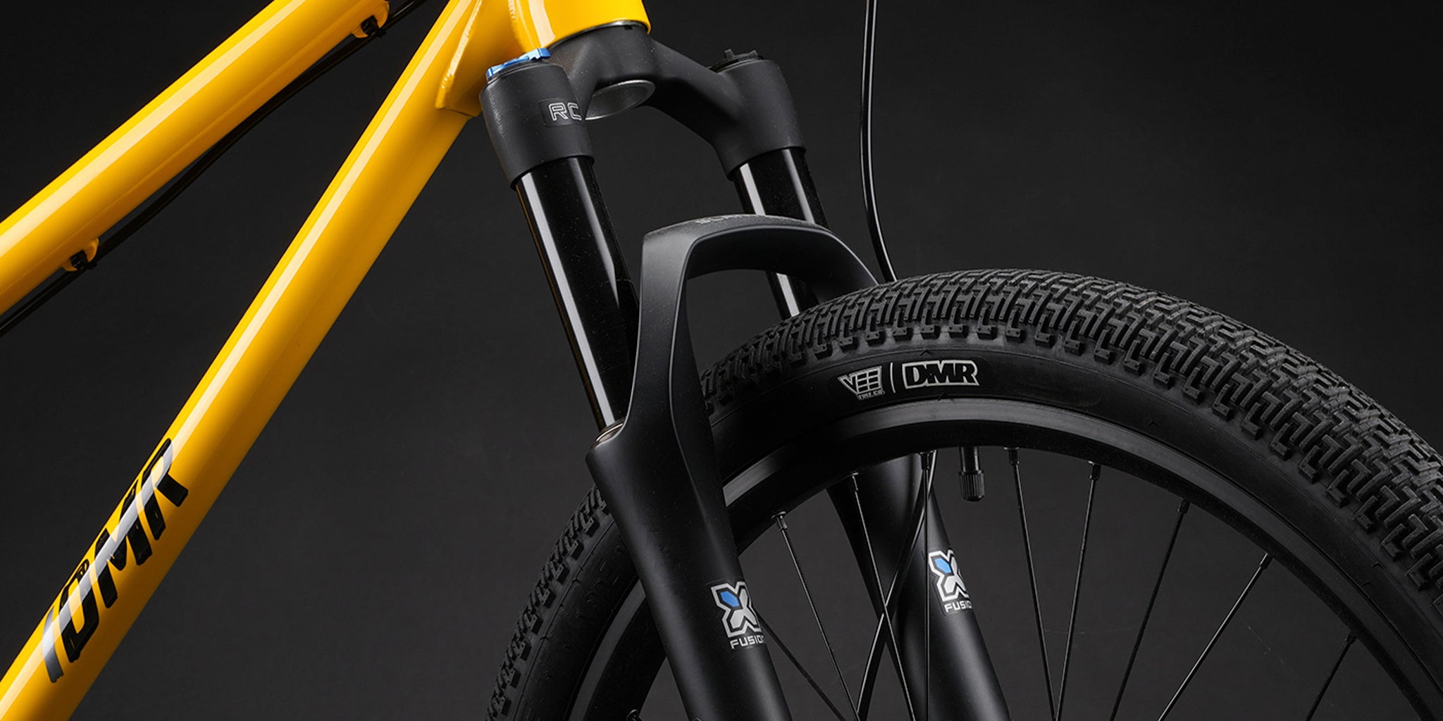 close-up of a dmr bikes sect pro dirt jumper bike frame in yellow, on a dark grey background