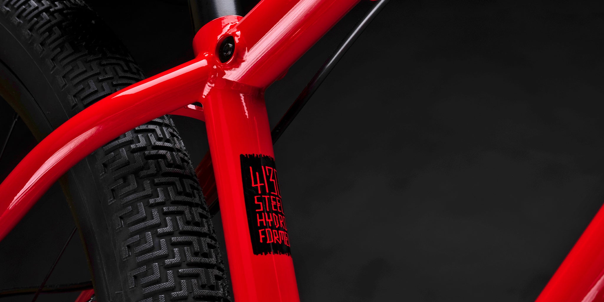close-up of a dmr bikes sect pro dirt jumper bike frame in red, on a dark grey background
